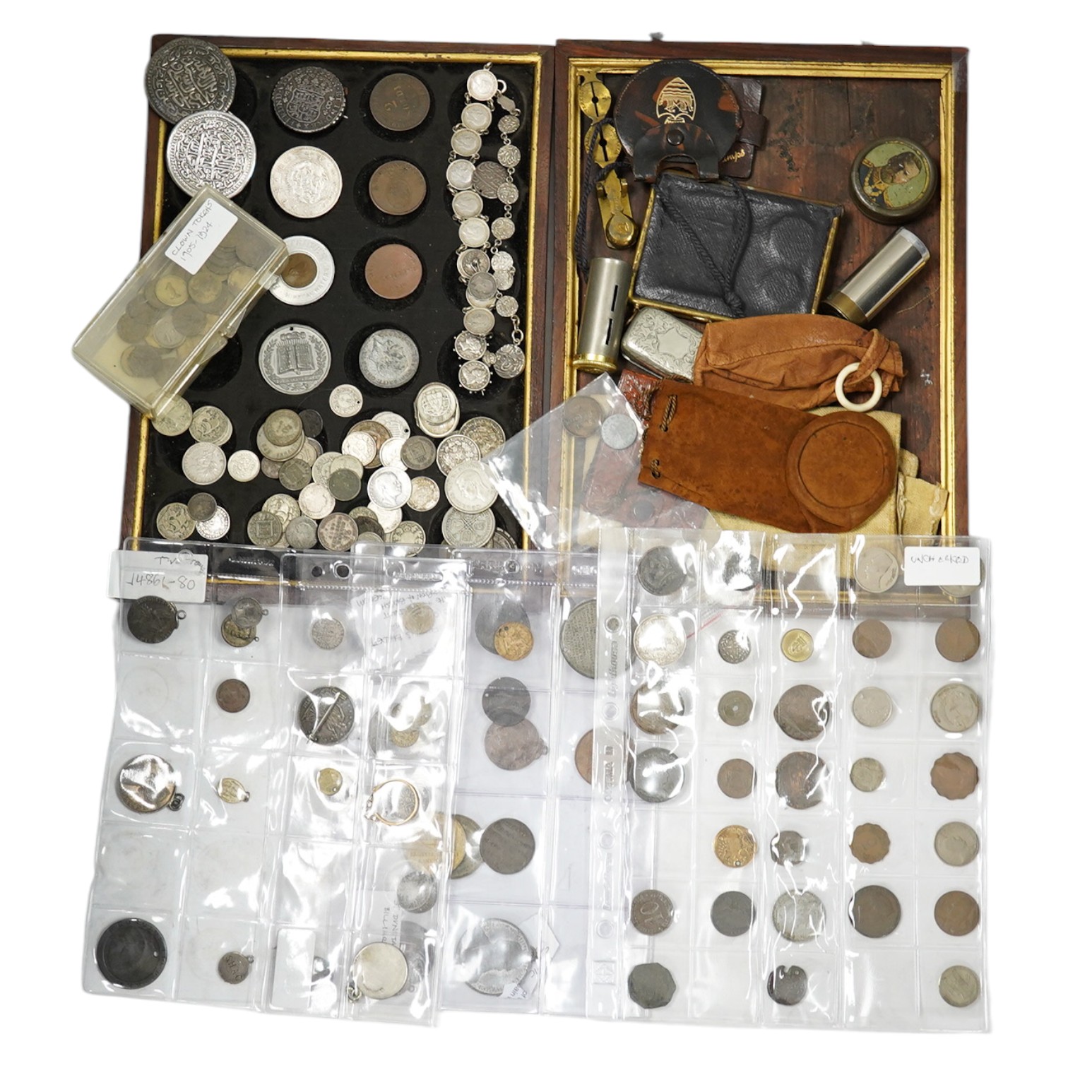 A collection of silver coins mounted as jewellery, pierced coins, commemorative medals, tokens and various coin wallets and sovereign scales